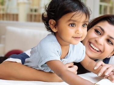 Smiling mother with arm around smiling child