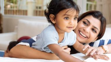 Smiling mother with arm around smiling child