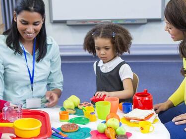 children and adults playing at a table